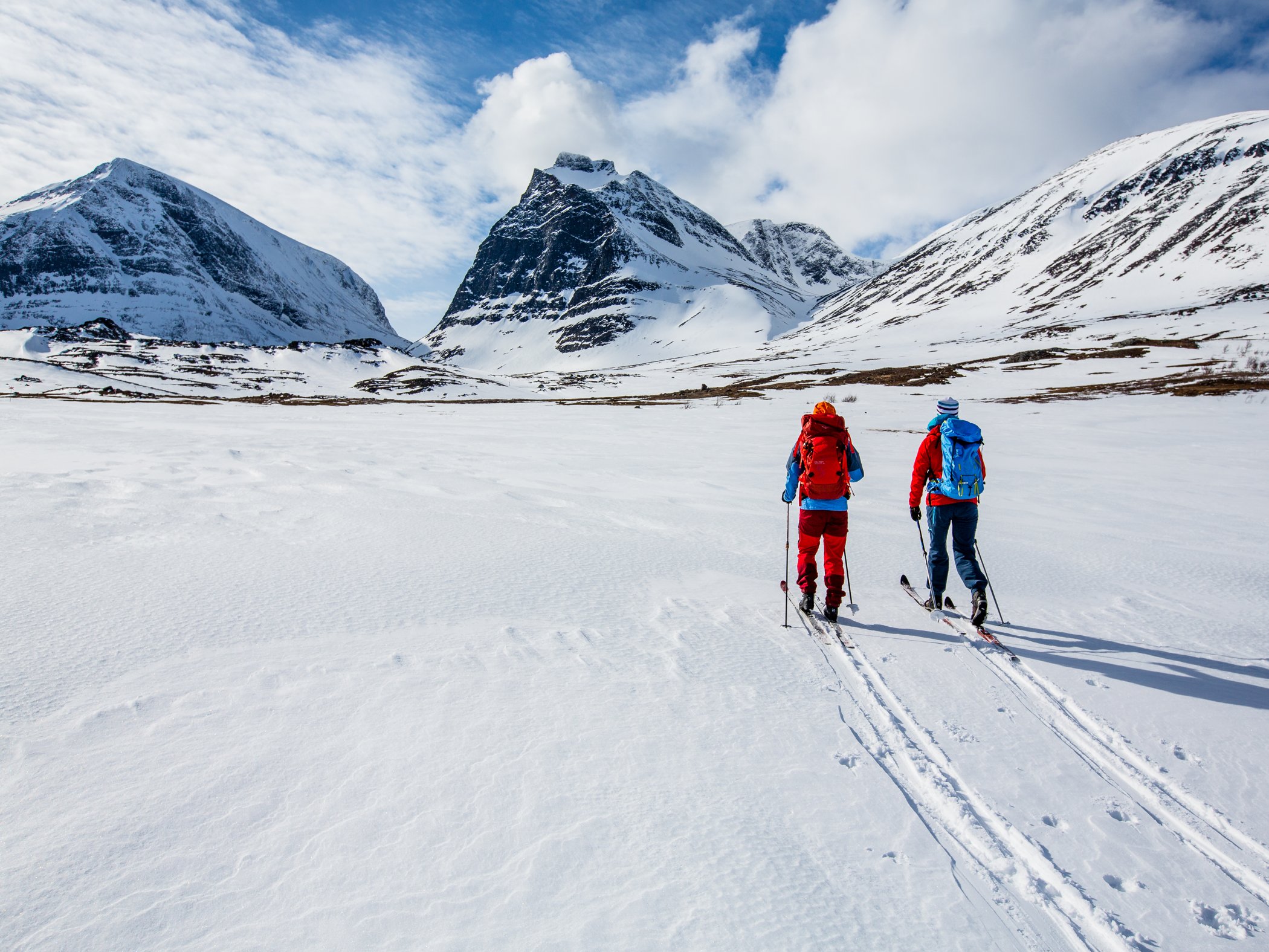 Two skiers on touring skis heading towards the Kebnekaise mountain massif.