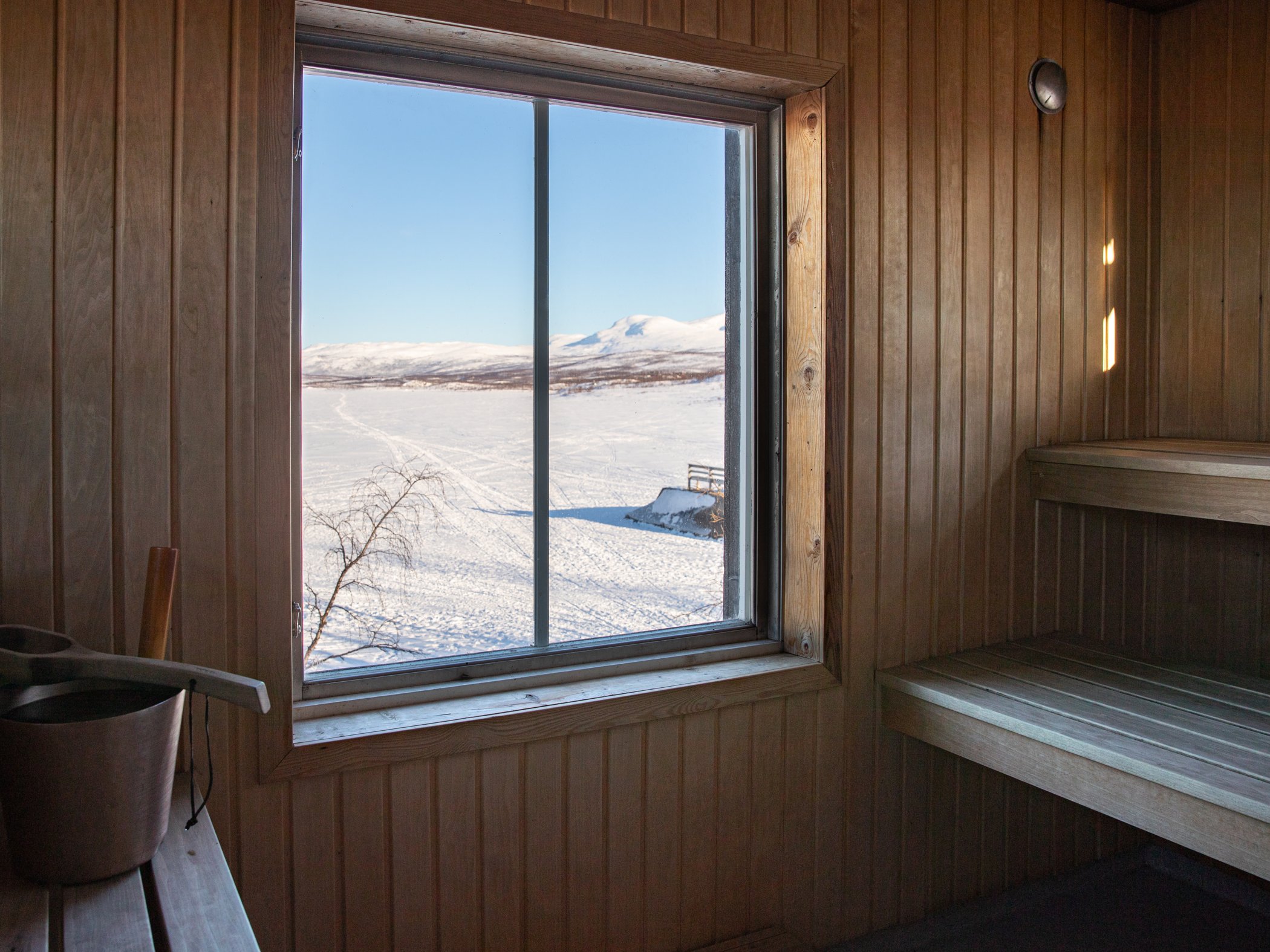 View of Lake Torneträsk and the mountains through the sauna window.