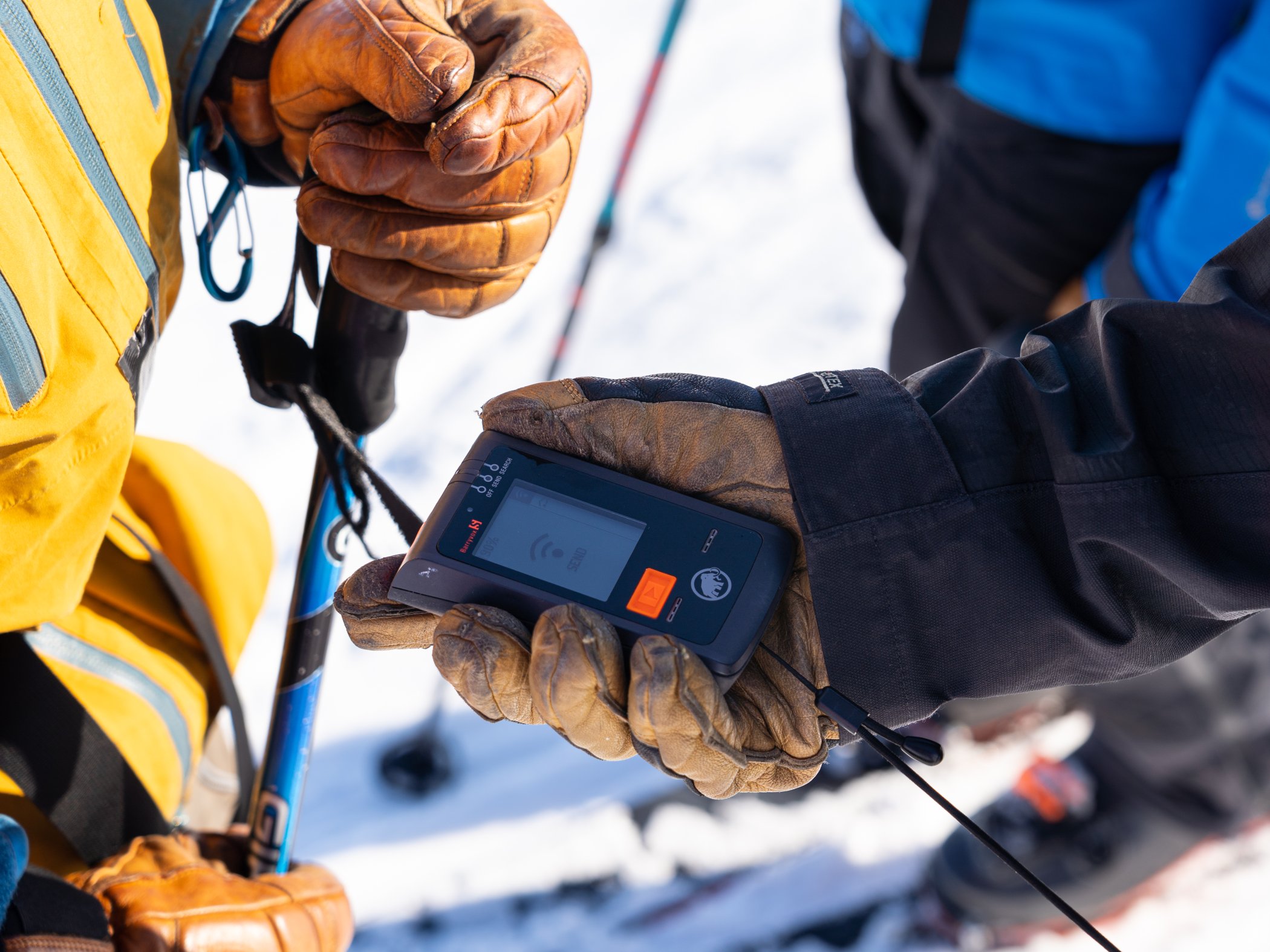 A close-up of an avalanche transceiver in a hand.