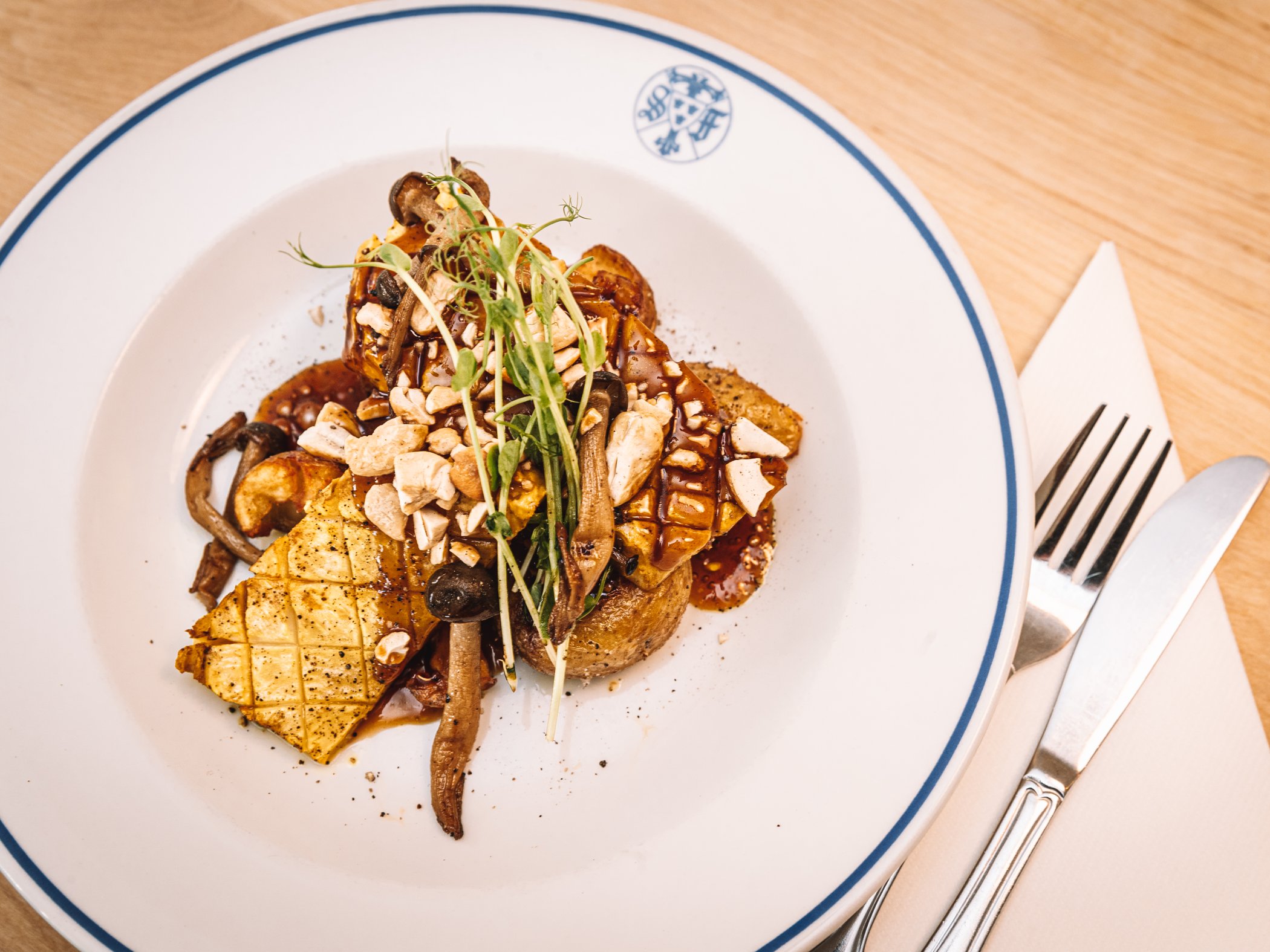 Restaurant dish with mushrooms, roasted potatoes and greens.