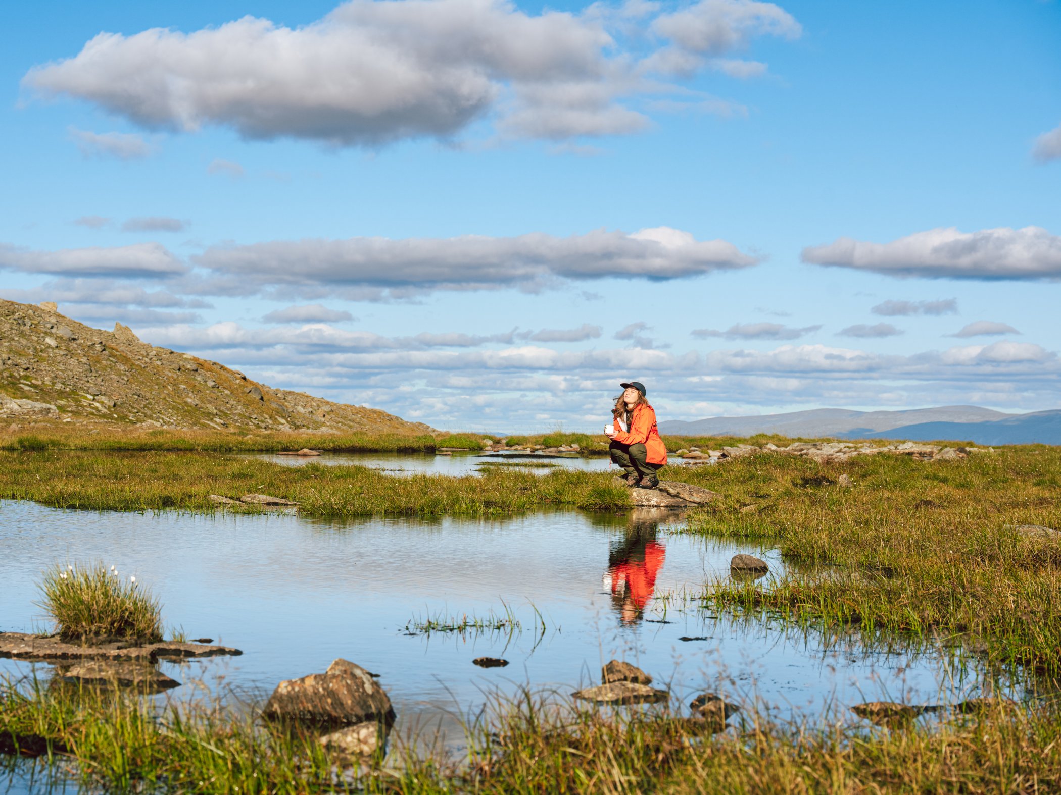 Hiker by a mountain tarn in the Helags mountains.