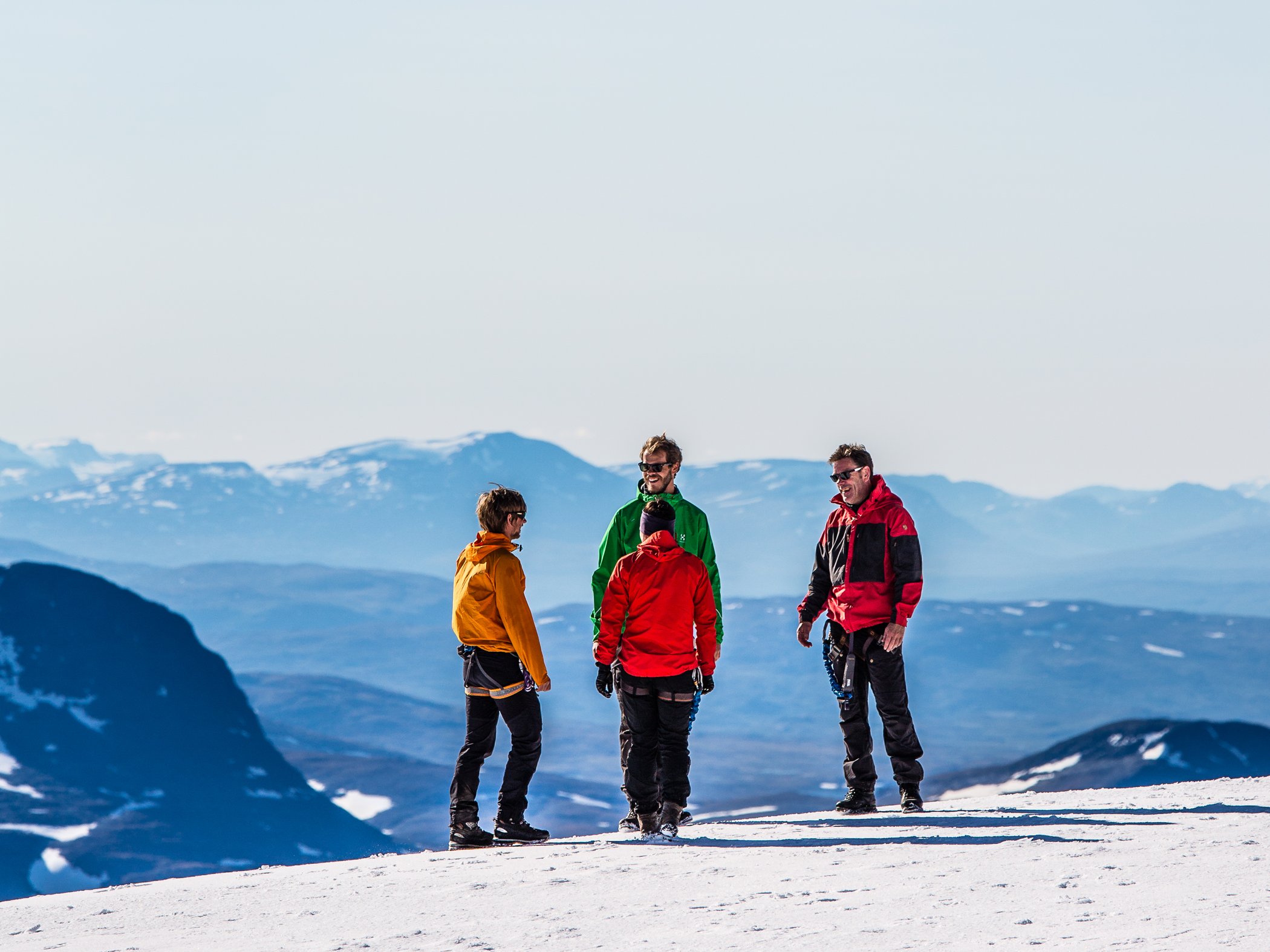 People standing on a snow-covered mountain with panoramic views.