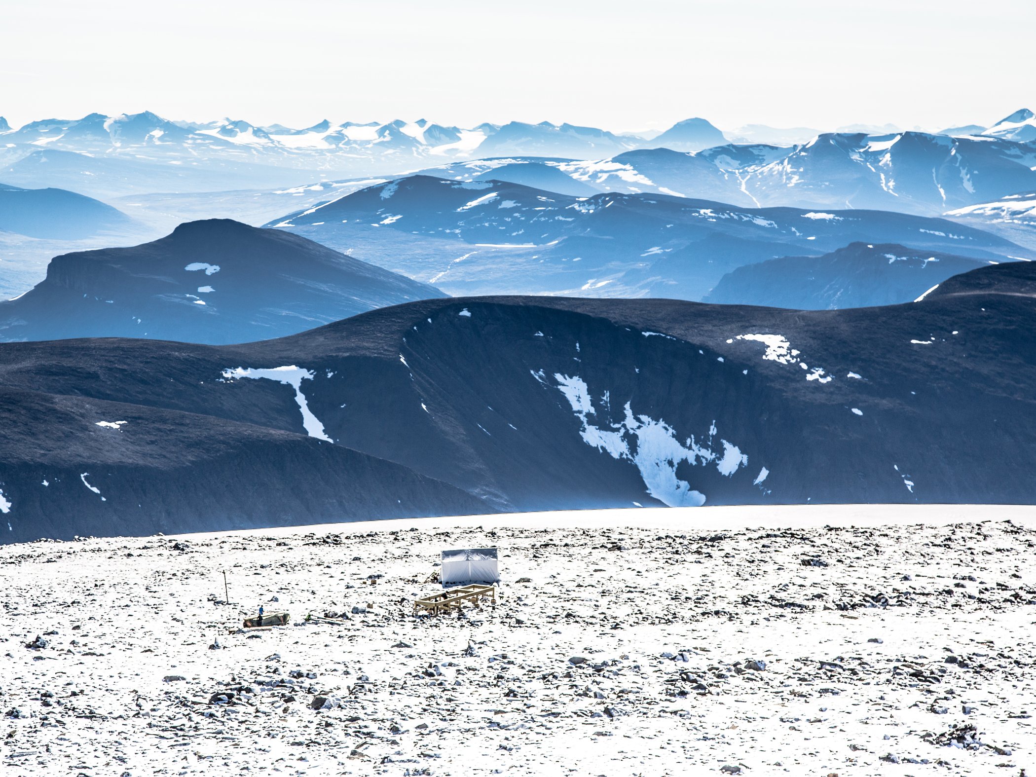 Snow-covered mountain landscape with distant peaks.