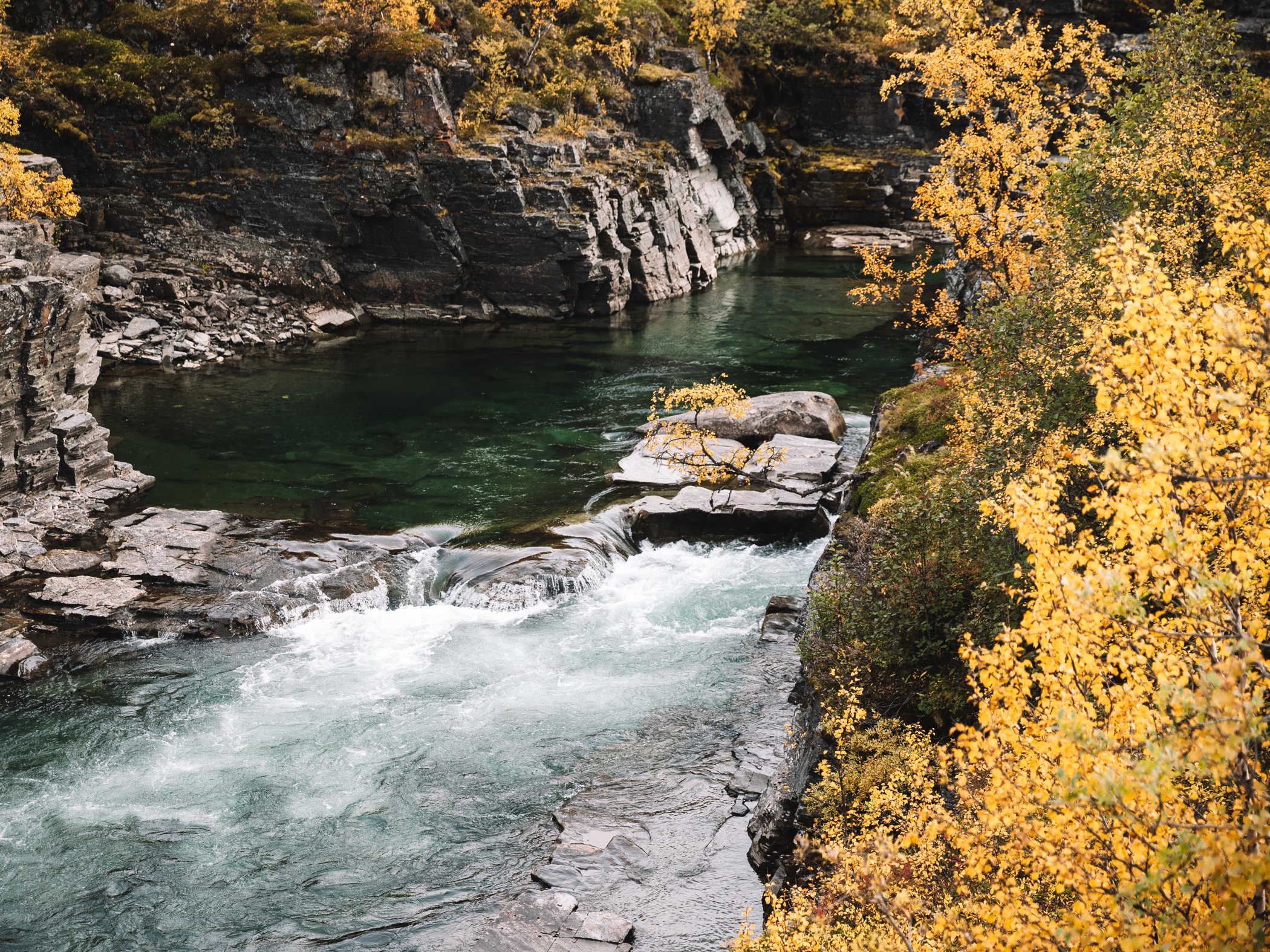 River flowing through a rocky canyon in autumn.