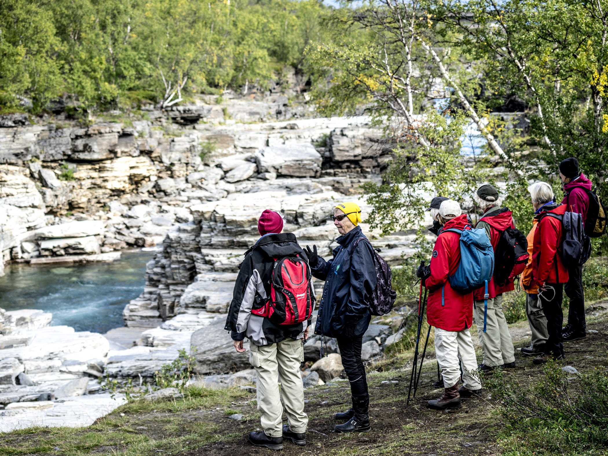 Guided hikers by a mountain river.