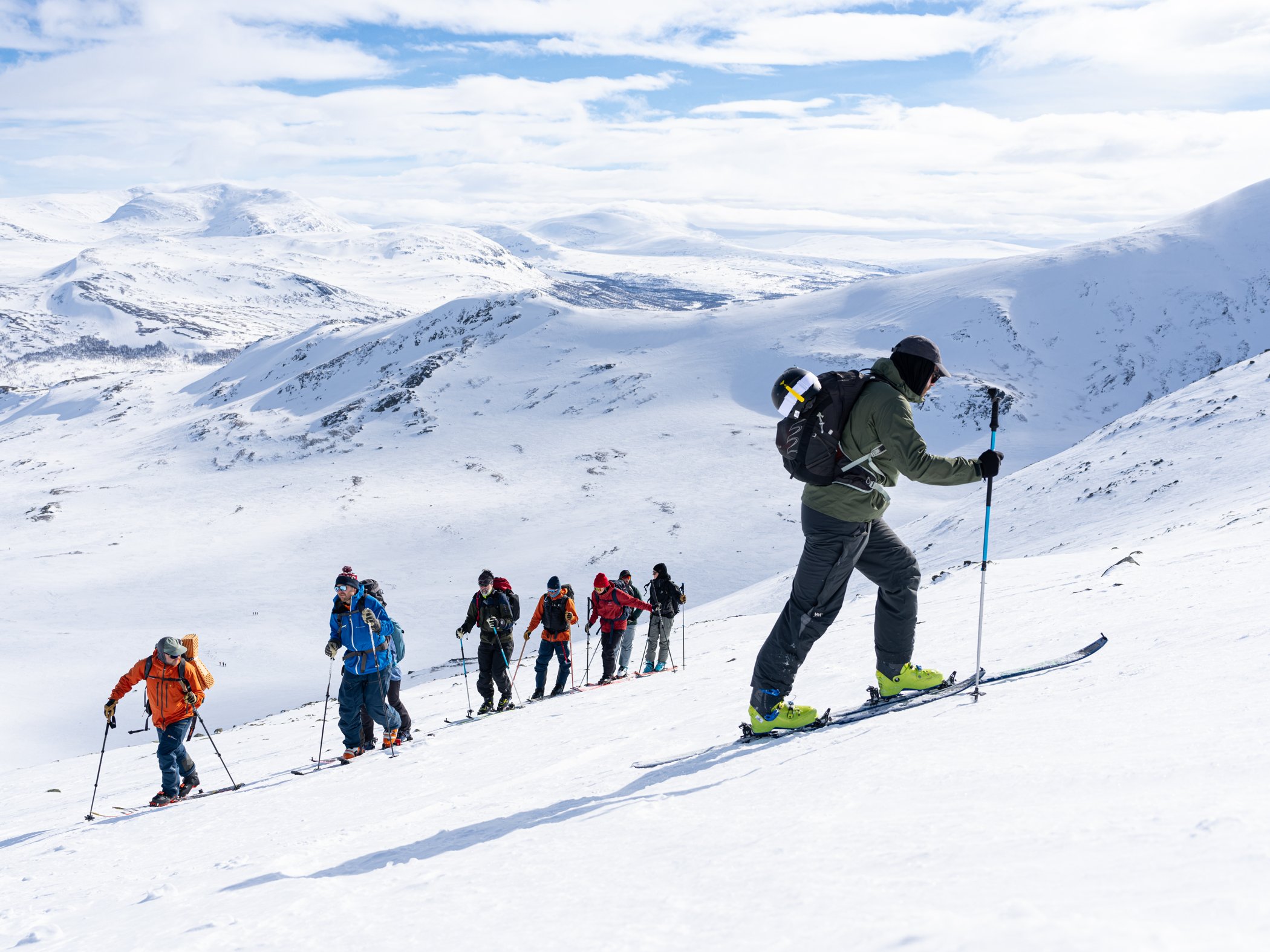 Grupp på topptur traverserar en snötäckt fjällsida vid Storulvån.