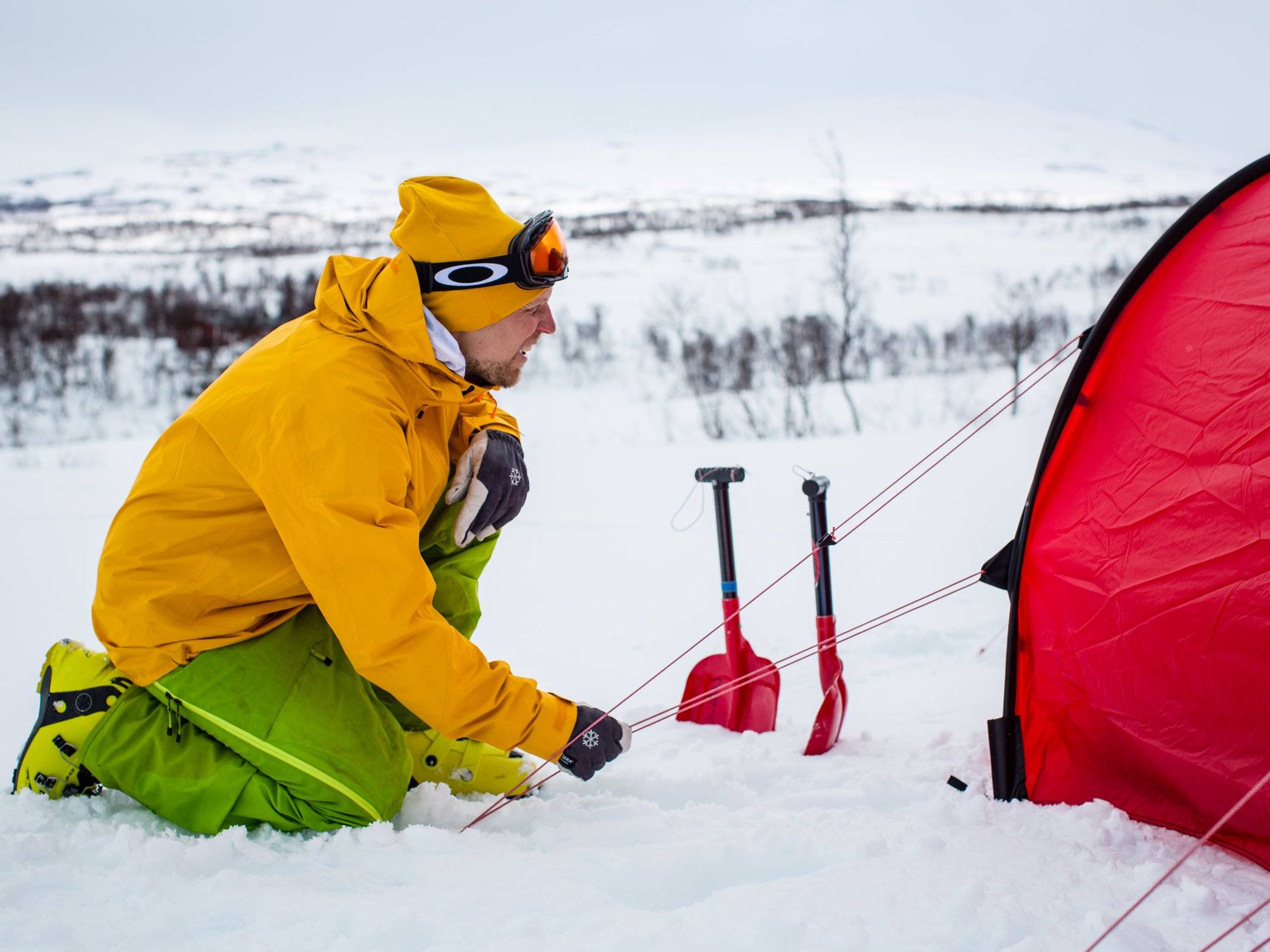 Man setting up tent during winter, Kebnekaise.